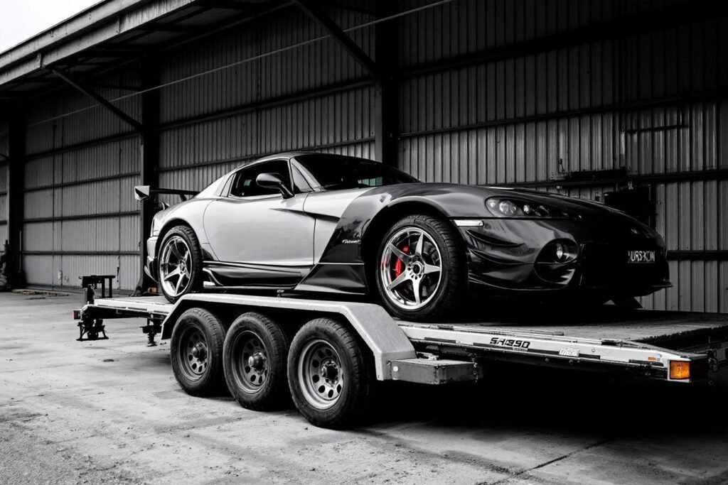 Supercar blanche et noire sur une remorque à trois essieux